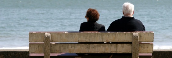 Ældre par på bænk ved hav